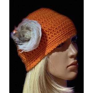 Women’s tangerine orange winter hat with a decorative feather brooch. by Sherri Gold