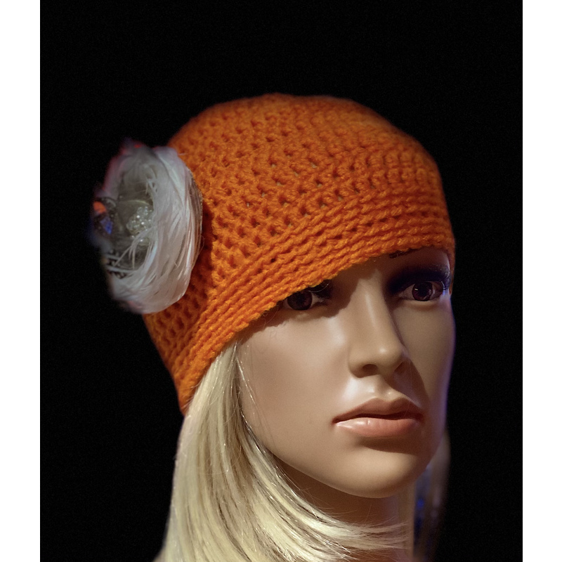Women’s tangerine orange winter hat with a decorative feather brooch. by Sherri Gold